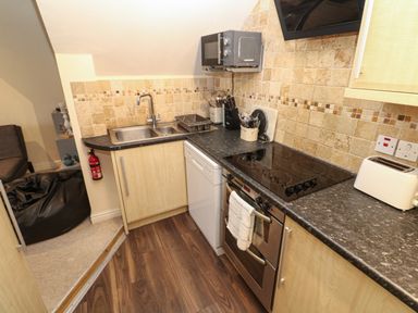 A kitchen with a sink microwave oven stove toaster and dishwasher at 5 Lyonesse Apartments in St Ives