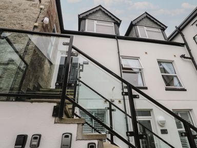 An exterior view of a building with stairs and glass railing at 5 Lyonesse Apartments in St Ives
