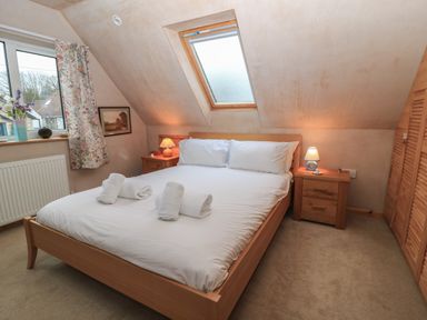 A bedroom with a double bed bedside tables and a skylight window at Old Harry Cottage 16 Swanage