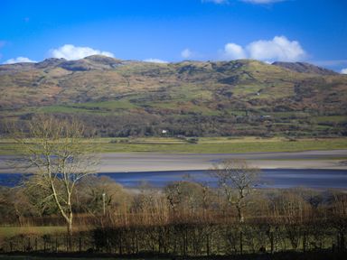 A rural landscape with trees a riverbed and hills in the background at Artists Cottage in Minffordd near Penrhyndeudraeth