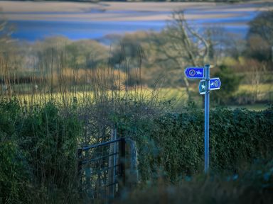 A countryside path with a metal gate and signposts for horse riders at Artists Cottage in Minffordd near Penrhyndeudraeth