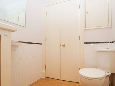 A bathroom with a toilet sink and cupboards at 6 Willows Green in Aldeburgh