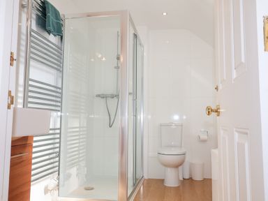 A bathroom with a shower cubicle a toilet and a towel rack at 6 Willows Green in Aldeburgh