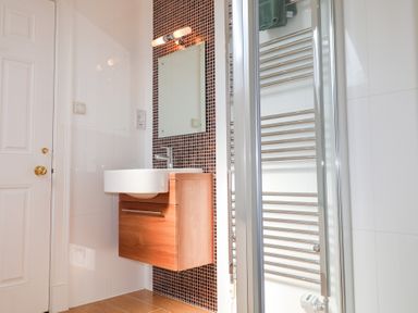 A bathroom with a wall-mounted sink cabinet mirror and towel warmer at 6 Willows Green in Aldeburgh