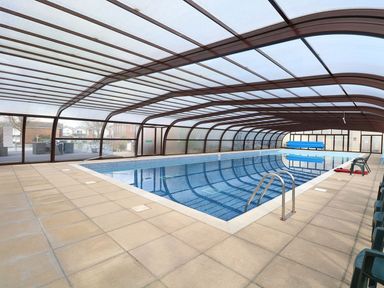 An indoor swimming pool with tiled floor and a transparent roof at 102 Waterside Park in Corton