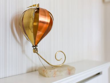 A metal hot air balloon sculpture on a white surface at Howard Cottage in North Littleton near Offenham