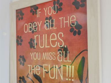 A framed sign on a wall with text and paw prints at Howard Cottage in North Littleton near Offenham