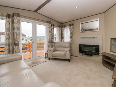 A living room with sofa and television at Aspen in Denny