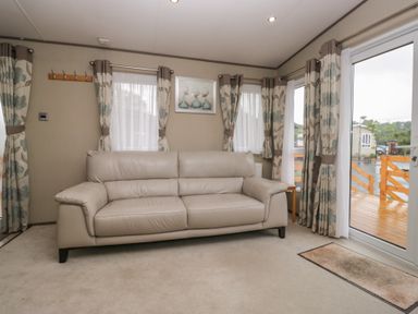 A living room with a sofa and curtains at Aspen in Denny