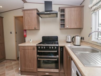 A kitchen with a gas oven and sink at Aspen in Denny