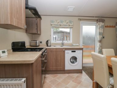 A kitchen with appliances and a dining table at Aspen in Denny
