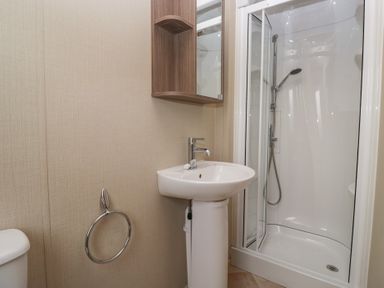 A bathroom with a shower, sink, and toilet at Aspen in Denny
