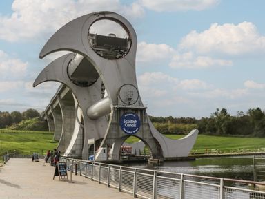 The Falkirk Wheel rotating boat lift on a canal with a pathway and railings alongside at Oak in Denny