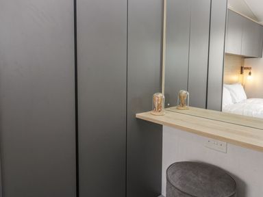 A bedroom with a wardrobe and a mirror at Ash in Denny