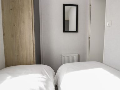 A bedroom with two beds and a mirror at Ash in Denny