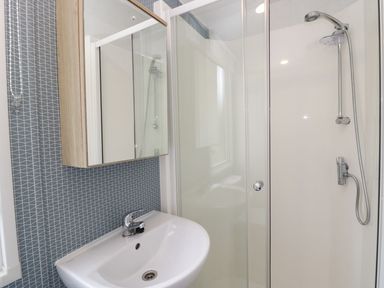 A bathroom featuring a shower, mirror, and sink at Ash in Denny
