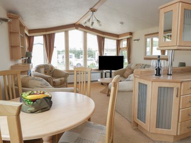 A living room with a dining table and sofa at Birch in Denny