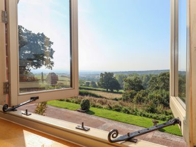 A view through an open window overlooking a garden and countryside at Sherway Shippen in Clyst Hydon near Bradninch