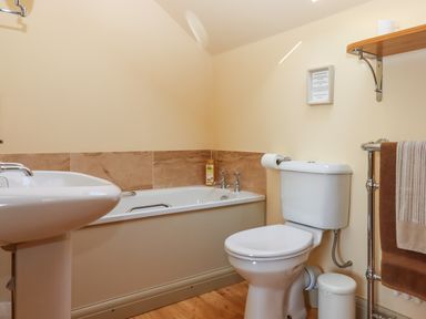 A bathroom with a bathtub a toilet a pedestal sink and a heated towel rail with towels at Sherway Shippen in Clyst Hydon near Bradninch