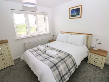 A bedroom with a bed and nightstands at 69 Ffordd Y Meillion in Llanelli