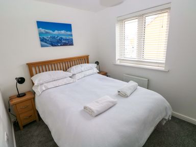 A bedroom with a bed and nightstand at 69 Ffordd Y Meillion in Llanelli