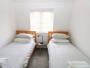 A bedroom with two single beds and a window at 69 Ffordd Y Meillion in Llanelli