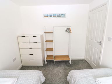 A bedroom with a dresser and a clothes rack at 69 Ffordd Y Meillion in Llanelli