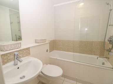 A bathroom with a sink toilet bathtub and shower at Forbes C1 in Yarmouth