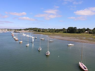 A river with sailboats moored along the shore and trees in the background at Forbes C1 in Yarmouth