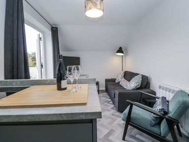 A living room with a sofa and wine glasses at Claife Flights in Bowness-On-Windermere
