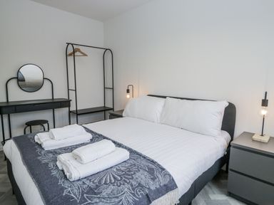 A bedroom with a bed and a clothes rack at Claife Flights in Bowness-On-Windermere