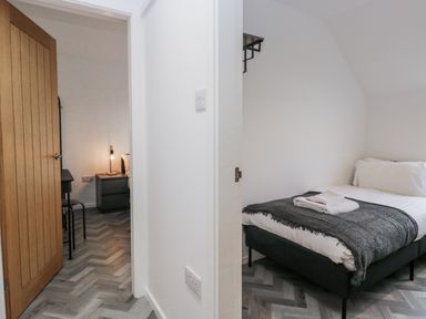 A bedroom with a bed, lamp, and chair at Claife Flights Bowness-On-Windermere