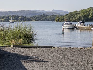 A person on a paddleboard near boats at Claife Flights in Bowness-On-Windermere