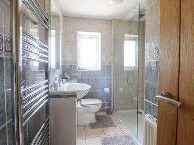 A bathroom with a shower, toilet, and sink at Ysgubor Newydd Parc Isaf Dyffryn Ardudwy