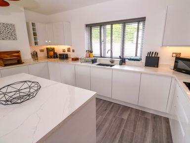 A kitchen with cabinets, sink, and appliances at Miramar St. Ives