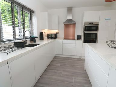 A kitchen with sink, oven, and cabinets at Miramar in St. Ives