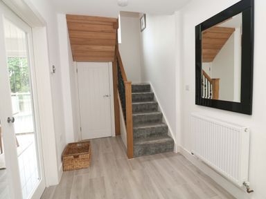 A hallway with a staircase and a mirror at Miramar St. Ives