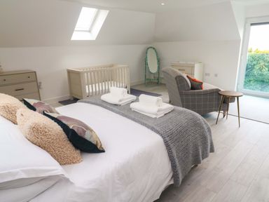 A bedroom with a crib and a dresser at Miramar in St. Ives
