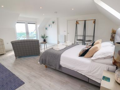 A bedroom with a bed and seating area at Miramar in St. Ives