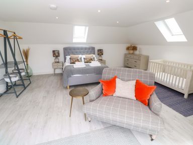A bedroom with a bed and a crib at Miramar in St. Ives