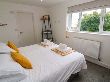 A bedroom with a bed and towels at Miramar in St. Ives