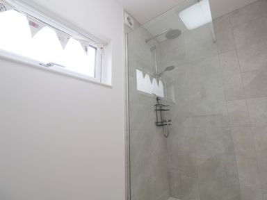 A bathroom featuring a shower with glass enclosure and a window at Miramar St. Ives