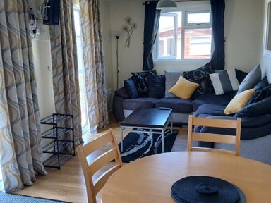 A living room with a sofa and coffee table at Gwanda in Tregolds near St Merryn
