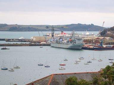 A harbor with docked ships cranes and small sailboats on the water at Fal View in Falmouth