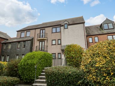 A multi-story residential building with balconies and bushes in front at Fal View in Falmouth