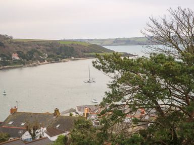 A bay with sailboats and houses along the shore with hills in the background at Fal View in Falmouth