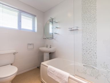 A bathroom with a toilet sink bathtub towel and window at Trestar in Polzeath
