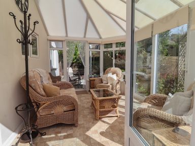 A conservatory with wicker furniture at Little Willesleigh Goodleigh near Barnstaple
