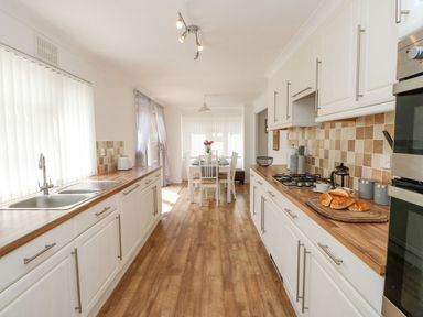 A kitchen with wooden countertops white cabinets and a dining table at Butterfly Lodge in Tunstall near Catterick North Yorkshire