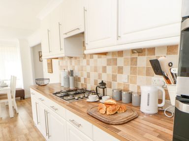 A kitchen counter with croissants on a wooden cutting board and a gas stove in Butterfly Lodge Tunstall near Catterick North Yorkshire